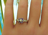 A charming flower style ring with oval tanzanite gemstones and diamonds in 14k yellow gold.