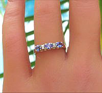 A stackable oval tanzanite ring with three east-west set gemstones in 14k yellow gold.