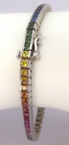 Princess cut rainbow sapphire bracelet in 14k white gold with a channel setting and hidden box clasp.