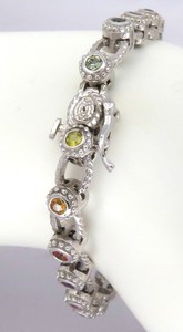 14k white gold bracelet featuring bezel set natural rainbow sapphires, creating a vibrant continuous pattern. 7 inches long.