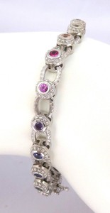 Bezel set rainbow sapphire bracelet in 14k white gold, featuring a continuous colorful pattern around a 7-inch wrist.