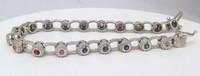 Bezel set rainbow sapphire bracelet in 14k white gold, featuring a continuous rainbow pattern and beaded edges.