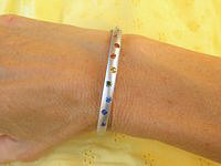 Rainbow sapphire bangle bracelet in 14k white gold with satin finishing, showcasing vibrant natural colors.