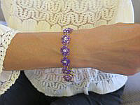 A stunning amethyst flower bracelet featuring 60 carats of rich purple gemstones set in white gold flowers with diamond centers.