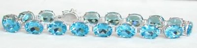 "Stunning blue topaz tennis bracelet in 14k white or yellow gold."