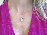 A charming 0.20 ctw diamond baby shoe pendant in 14k white gold with a delicate strap.