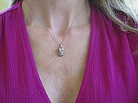 A charming baby shoe pendant with chocolate brown and white diamonds in 18k white gold.