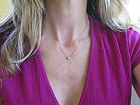 A delicate round diamond solitaire necklace on a 16-inch chain.