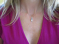 A charming 14k white gold baby shoe pendant with 0.12 ctw diamonds.