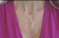 An elegant elongated loop pendant in 14k white gold with stunning diamond accents.