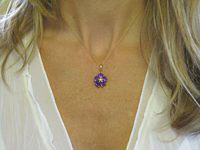 A stunning flower design pendant featuring heart-shaped amethyst stones in 14k gold setting.