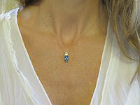 A stunning oval cut Natural Buff Top Blue Topaz pendant set in 14k gold.