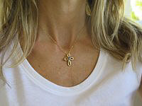 A stunning tanzanite cross pendant in 14k yellow gold.