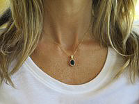 "Oval iolite and diamond halo pendant in 14k yellow gold, perfect for daily wear."