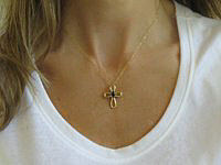 A stunning blue sapphire cross pendant in luxurious 14k yellow gold.