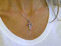 A stunning rainbow sapphire cross pendant with princess cut sapphires in vibrant colors.