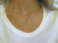 "Elegant light pink sapphire and diamond halo pendant in 14k white gold."