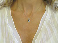 A stunning Ceylon blue sapphire pendant with diamond halo in white gold.