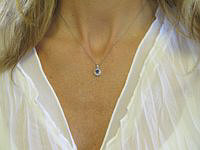 A stunning Ceylon purple sapphire pendant with a diamond halo in white gold.