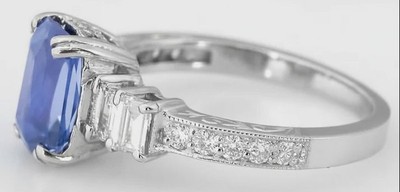 Radiant cut Ceylon sapphire ring with baguette and round diamonds in engraved 18k white gold setting.