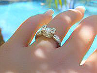 A unique 0.83 carat diamond engagement ring in 18k white gold with tear drop shaped prongs and intricate diamond accents.