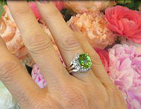 A stunning oval peridot and diamond ring with a triple split shank design in 14k white gold.