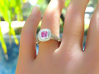 Pink sapphire and diamond halo ring in platinum with milgrain detail, featuring a stunning bubble gum pink sapphire surrounded by sparkling diamonds and intricate design.