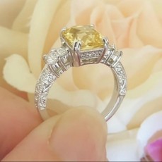 Unheated yellow sapphire engagement ring in 18k white gold, featuring a radiant cut and vintage-style diamond accents.