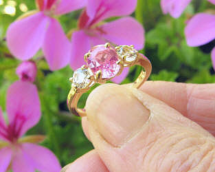 Natural Oval Pink Sapphire and Round White Sapphire Three Stone Ring in 14k yellow gold for sale