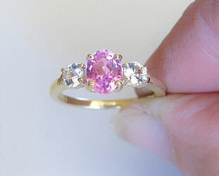 Natural Oval Pink Sapphire and Round White Sapphire Three Stone Engagement Ring in 14k yellow gold for sale