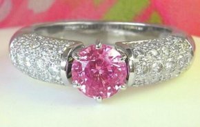 A stunning round pink sapphire ring with pave diamonds in 18k white gold, exuding elegance and femininity.