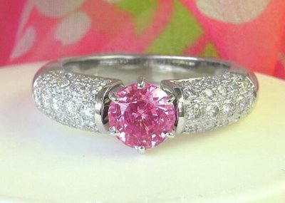 A stunning round pink sapphire ring with pave diamonds in 18k white gold, exuding elegance and femininity.