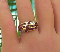 A stylish 14k yellow gold ring with square cut rubies, diamond accents, and a unique swirl design.