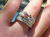Elegantly designed round diamond engagement ring and matching band in 18k white gold with intricate milgrain detailing and bezel set diamonds.