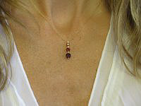 Delicate garnet pendant and earring set with 3-stone styling and pear-shaped dangles.