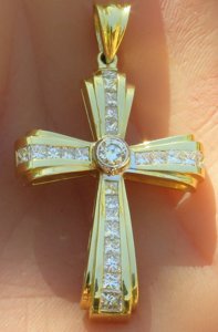 A stunning princess cut diamond cross pendant with a round diamond bezel set center in lustrous 14k yellow gold.
