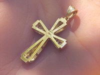 Shimmering princess cut diamond cross pendant with round diamond center in 14k yellow gold.
