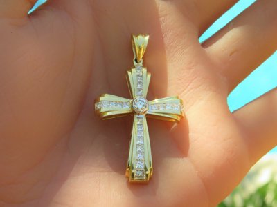 Stunning princess cut diamond cross pendant with round diamond bezel set center in 14k yellow gold.