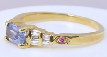 Radiant cut blue sapphire and pink sapphire ring with baguette diamonds in 14k yellow gold setting.